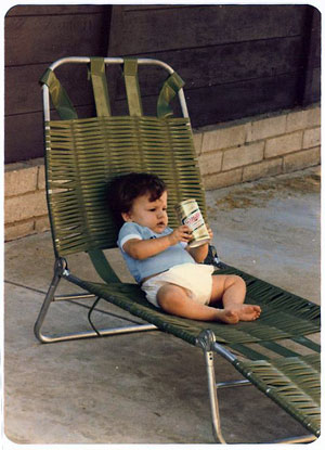 joe as a baby drinking water from a Miller beer can