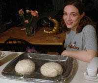 Michelle sitting in front of two large dough balls...