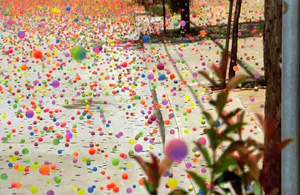an image of a bunch of colored bouncy balls pooring down a sidewalk
