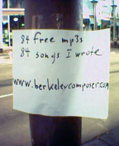 a piece of paper taped to a signpost in Berkeley, CA in 2004 that says, 84 free mp3s 84 songs I wrote www dot berkeleycomposer dot com